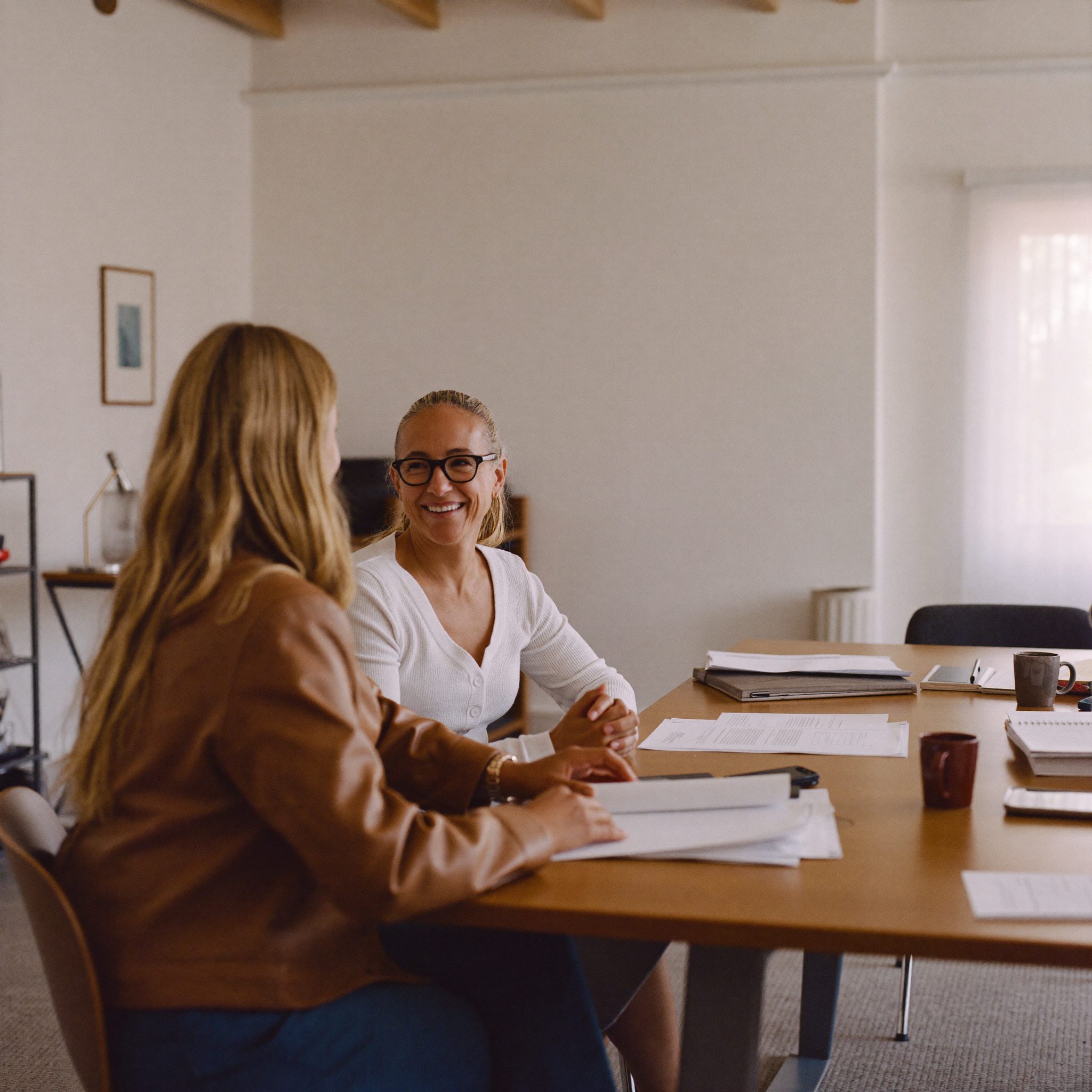 Two people in conversation across a desk in a Vorenta office