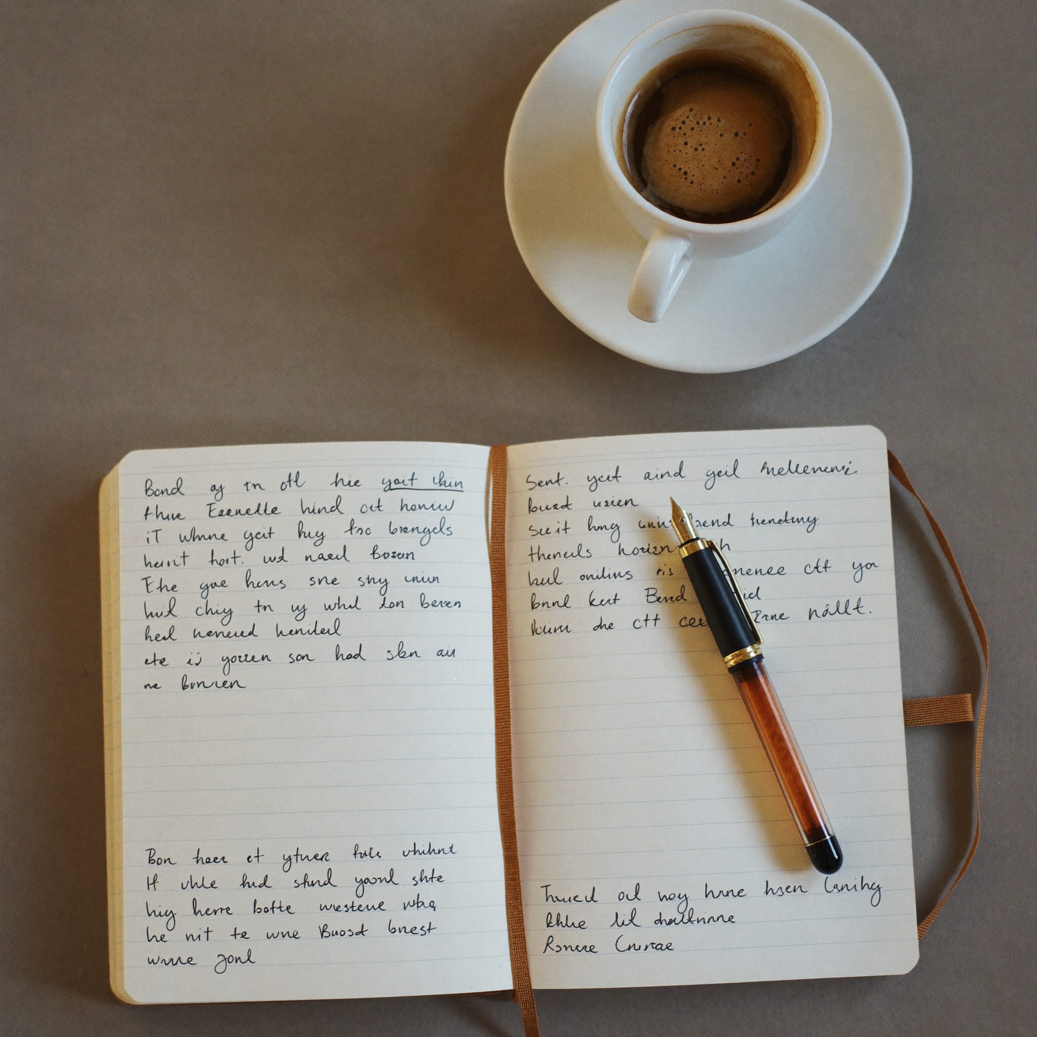 A notebook, pen and coffee on a desk